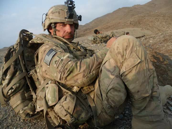 Phillip Adams during his U.S. Army service, in full kit on a hillside in Afghanistan